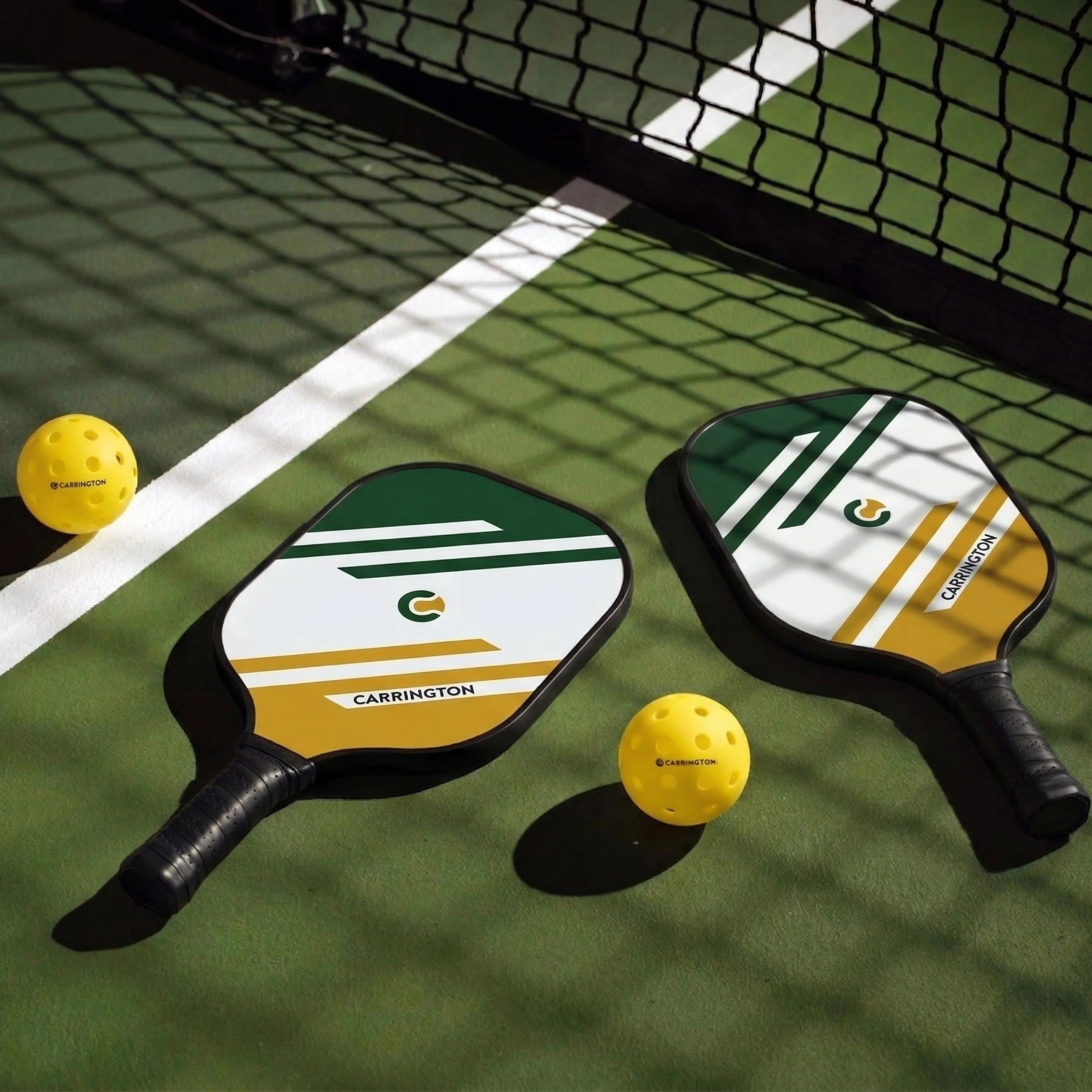 Two pickleball paddles and balls on a pickleball court